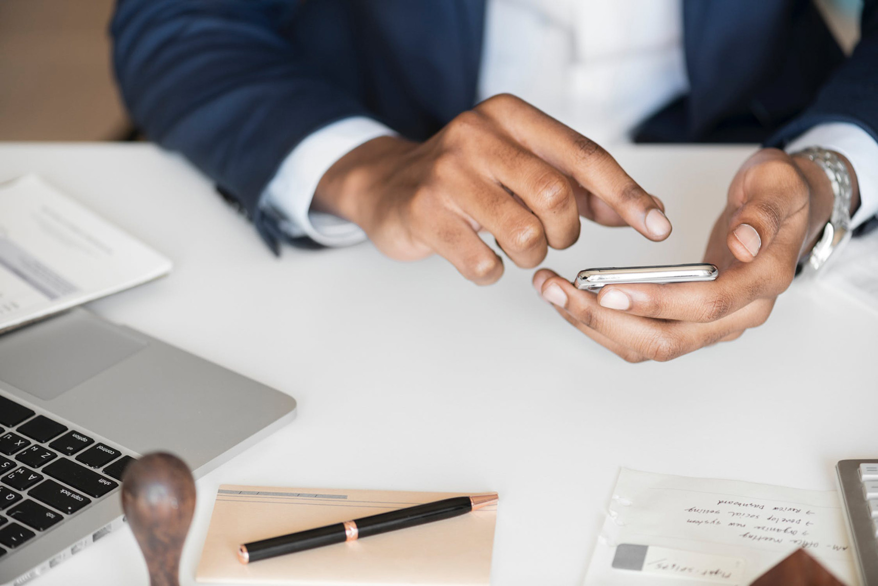 A man at his desk with papers, laptop, and a phone